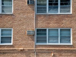 Close-up of a brick apartment facade featuring multiple modern aluminum windows.