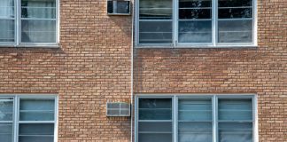 Close-up of a brick apartment facade featuring multiple modern aluminum windows.