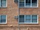 Close-up of a brick apartment facade featuring multiple modern aluminum windows.