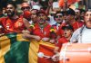 Group of diverse soccer fans cheering passionately, waving flags and celebrating in a vibrant parade.