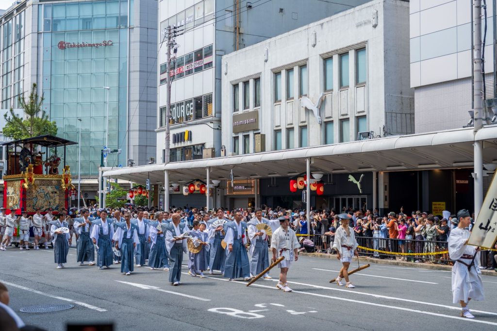 Traditional Gion Festival parade in Kyoto with participants in traditional attire.
