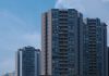 Tall city skyscrapers with multiple windows against a clear blue sky, epitomizing urban architecture.