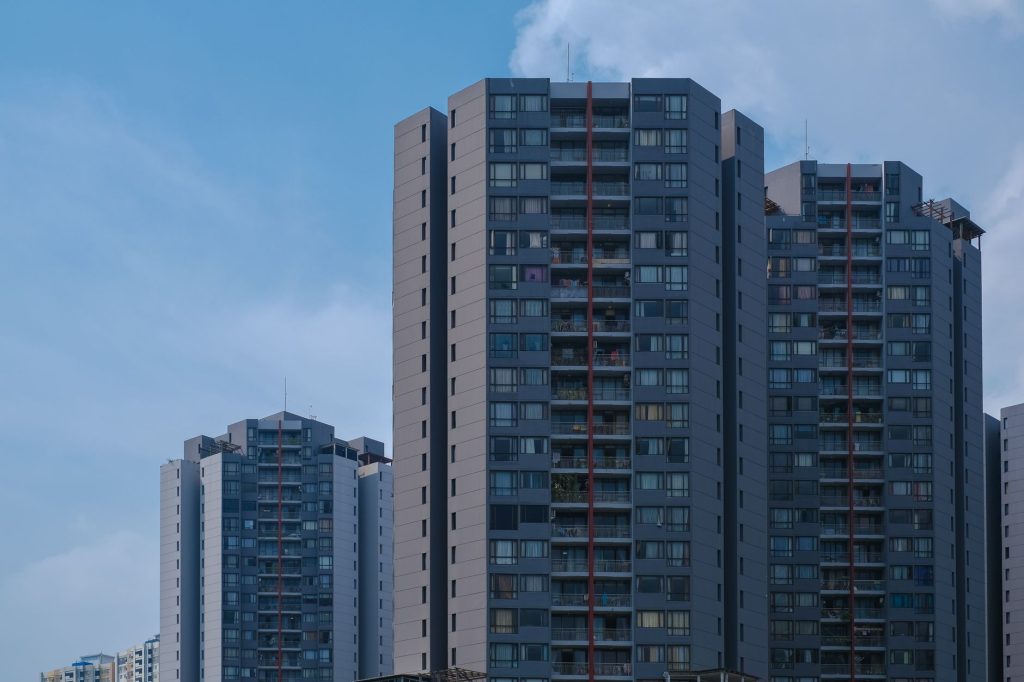 Tall city skyscrapers with multiple windows against a clear blue sky, epitomizing urban architecture.