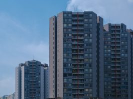 Tall city skyscrapers with multiple windows against a clear blue sky, epitomizing urban architecture.