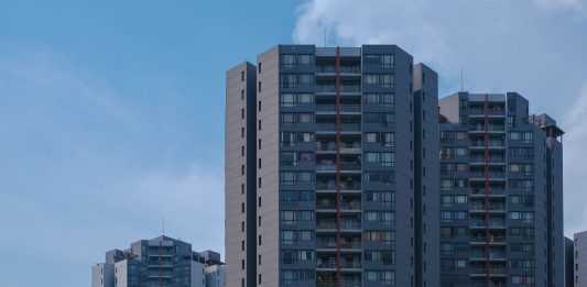 BREAKING: Casa One Debuts 196 Rentals in Jersey City’s Journal Square Tall city skyscrapers with multiple windows against a clear blue sky, epitomizing urban architecture.