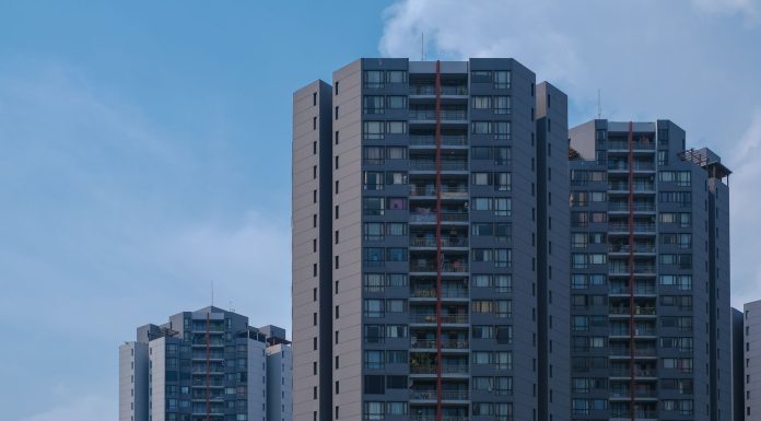 Tall city skyscrapers with multiple windows against a clear blue sky, epitomizing urban architecture.