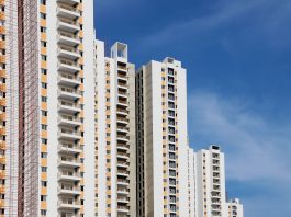 BREAKING: Elizabeth Ave Tower Near Newark Gets $70M Loan Modern high-rise residential buildings with white facades and blue sky backdrop showcasing urban architecture.