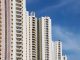 Modern high-rise residential buildings with white facades and blue sky backdrop showcasing urban architecture.