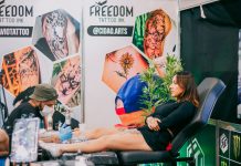 Tattoo artist creating detailed art in a vibrant studio setting.