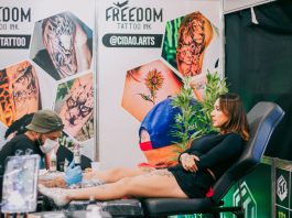 Tattoo artist creating detailed art in a vibrant studio setting.