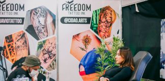 Tattoo artist creating detailed art in a vibrant studio setting.