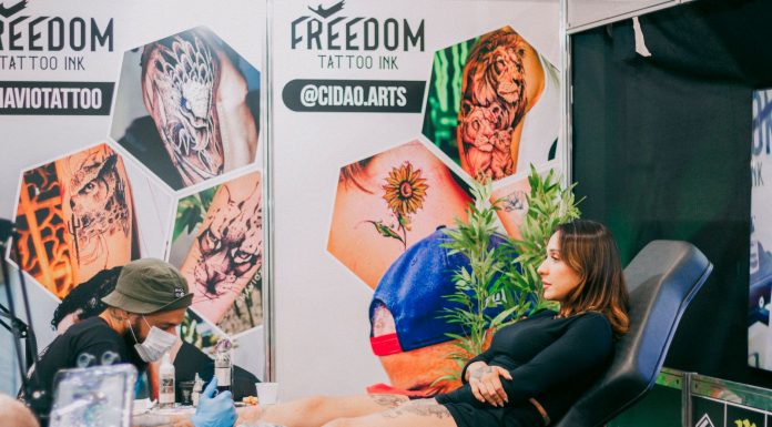 Tattoo artist creating detailed art in a vibrant studio setting.