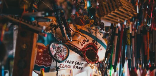 A colorful array of souvenir keychains and pens hanging in a shop.