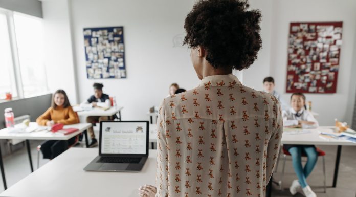 Female teacher engaging students in a classroom setting with diverse learners.