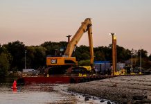 An excavator on a barge near Cove Island Park Marina during twilight in Stamford, Connecticut.