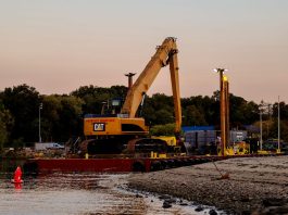 BREAKING: Passaic River Cleanup Moves To In-River Construction An excavator on a barge near Cove Island Park Marina during twilight in Stamford, Connecticut.