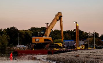 BREAKING: Passaic River Cleanup Moves To In-River Construction An excavator on a barge near Cove Island Park Marina during twilight in Stamford, Connecticut.