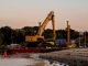 An excavator on a barge near Cove Island Park Marina during twilight in Stamford, Connecticut.