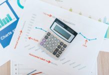 Calculator placed on financial graphs and reports showcasing data analysis and business documentation.