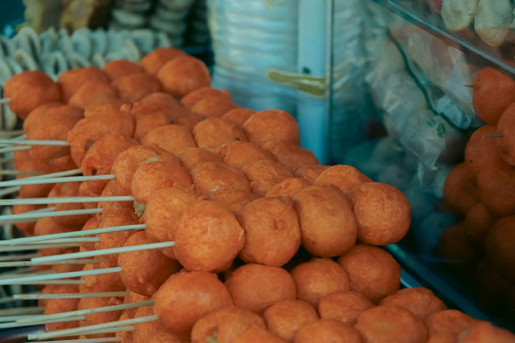 Close-up of skewered fried street food balls, perfect for food and travel visuals.