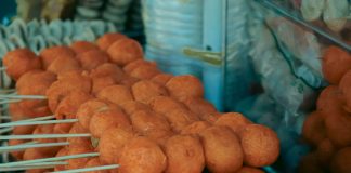Close-up of skewered fried street food balls, perfect for food and travel visuals.