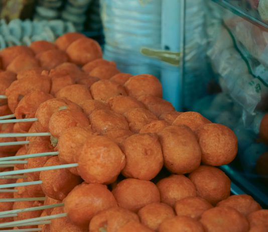 Close-up of skewered fried street food balls, perfect for food and travel visuals.