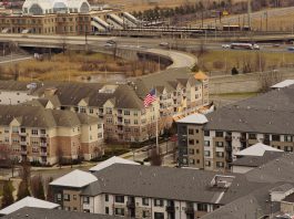 Aerial view of urban residential apartments featuring an American flag, depicting city life.