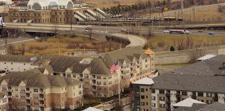 Aerial view of urban residential apartments featuring an American flag, depicting city life.