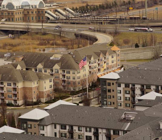 Aerial view of urban residential apartments featuring an American flag, depicting city life.