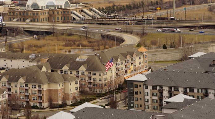 Aerial view of urban residential apartments featuring an American flag, depicting city life.