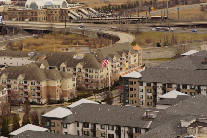 Aerial view of urban residential apartments featuring an American flag, depicting city life.