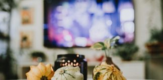Stylish autumn decoration with pumpkins and candles in a cozy living room setting.