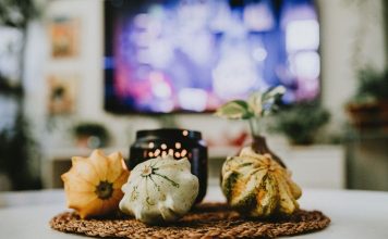 Stylish autumn decoration with pumpkins and candles in a cozy living room setting.
