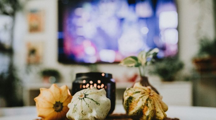 Stylish autumn decoration with pumpkins and candles in a cozy living room setting.