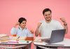 High Tech Senior Named National Merit Semifinalist Father and son joyfully celebrate finishing homework together on a laptop.