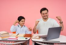High Tech Senior Named National Merit Semifinalist Father and son joyfully celebrate finishing homework together on a laptop.