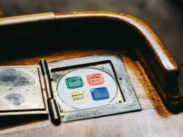 Wooden voting panel with multilingual buttons in Bern's Parliament, Switzerland.