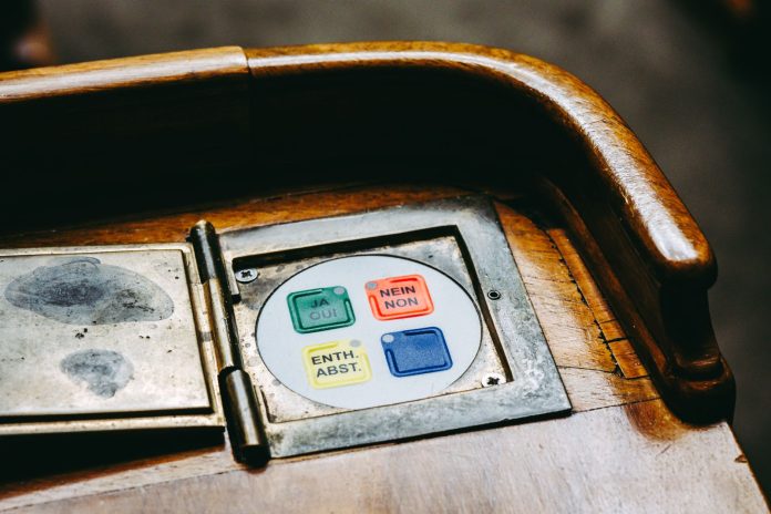 hoboken-approves-11-2m-bond-for-trucks-roads-and-h Wooden voting panel with multilingual buttons in Bern's Parliament, Switzerland.