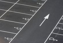 A clean parking lot featuring multiple handicapped spaces and a directional arrow marking.