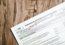 Jersey City Landlord: Small Property Owners Are ‘Modern-Day Indentured Servants’ Close-up of a corporate tax form on a textured wooden surface, highlighting document details.