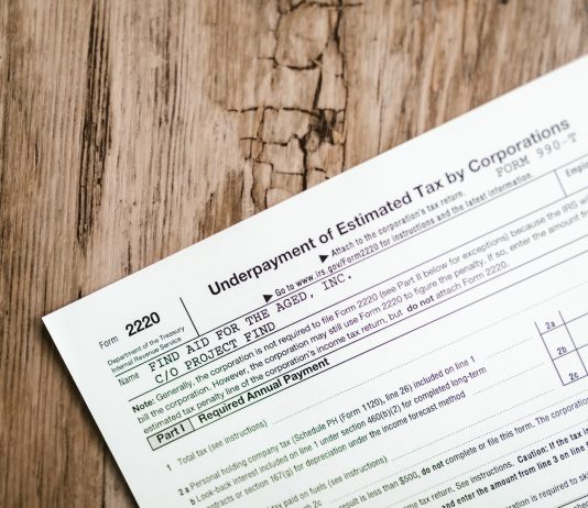 Close-up of a corporate tax form on a textured wooden surface, highlighting document details.