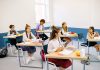 Students learning in a bright, diverse classroom setting, engaged and attentive.