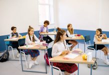 Students learning in a bright, diverse classroom setting, engaged and attentive.