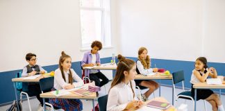 Students learning in a bright, diverse classroom setting, engaged and attentive.