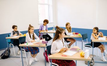 Students learning in a bright, diverse classroom setting, engaged and attentive.