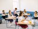 Students learning in a bright, diverse classroom setting, engaged and attentive.