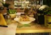 Delicious pasta dish with herbs in a warm restaurant ambiance, ideal for food lovers.