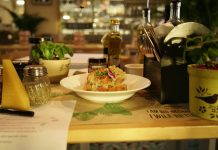 Delicious pasta dish with herbs in a warm restaurant ambiance, ideal for food lovers.