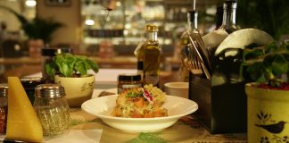 Delicious pasta dish with herbs in a warm restaurant ambiance, ideal for food lovers.
