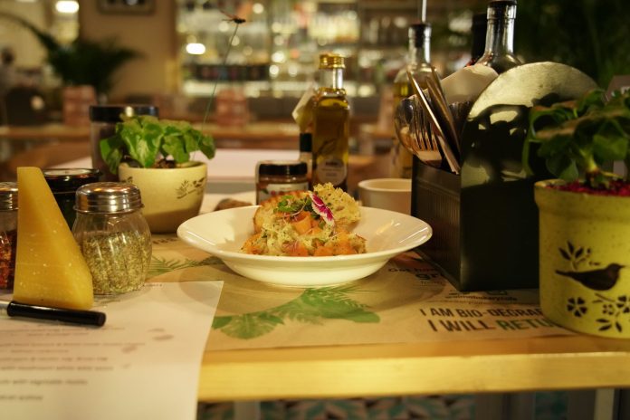 Delicious pasta dish with herbs in a warm restaurant ambiance, ideal for food lovers.